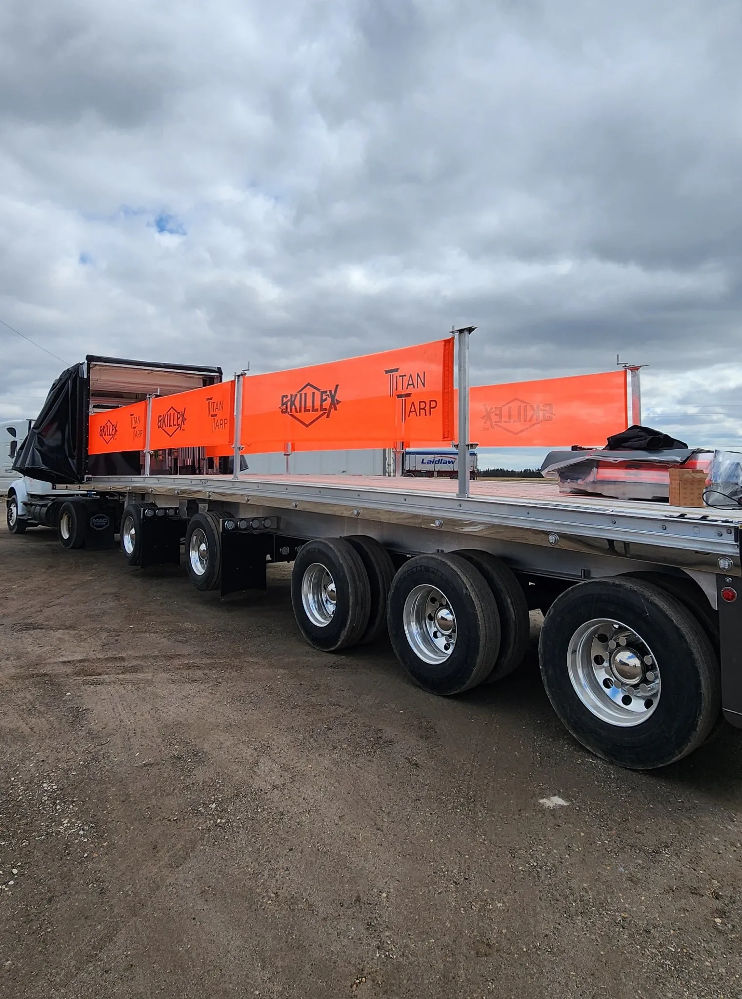 An orange fall prevention barrier running the length of a flatbed trailer