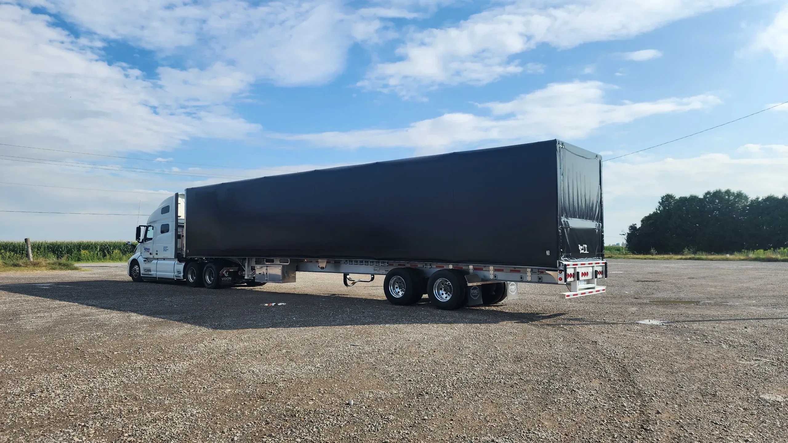 A flatbed trailer fitted with a Titan sliding tarp system, tarped and ready to run