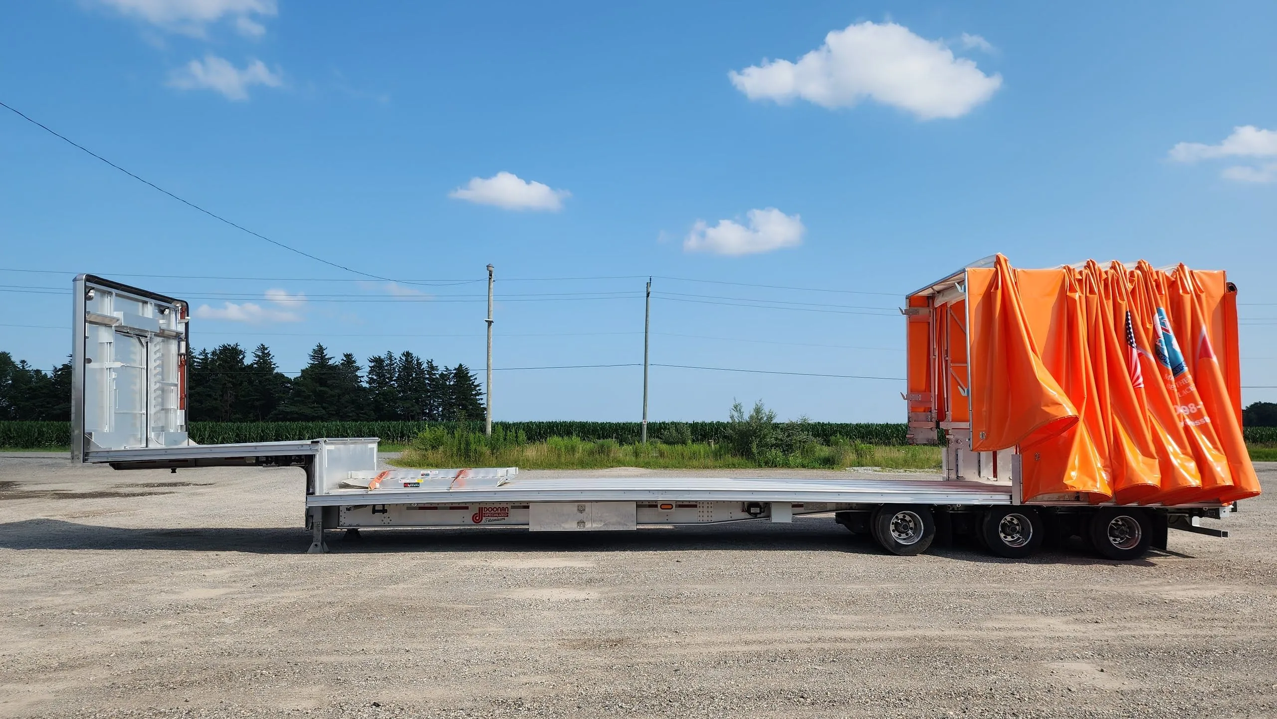 A Titan tarp system gathered at the front of a step deck trailer, leaving both decks open for loading