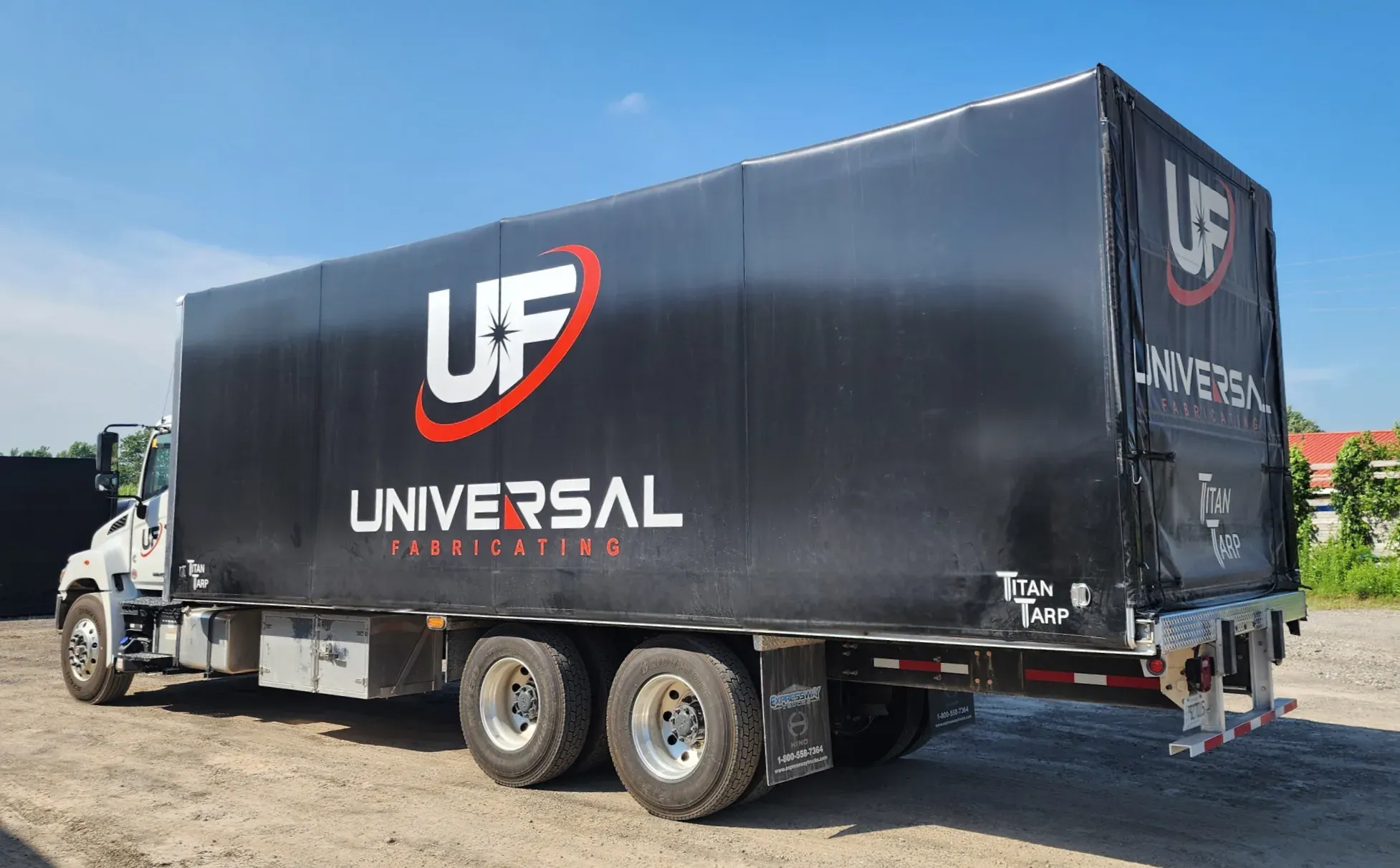 A truck body fitted with a black Titan tarp system, seen from the rear