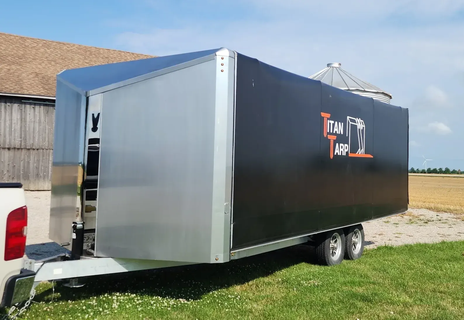 A Titan Tarp branded utility trailer with a black sliding tarp system